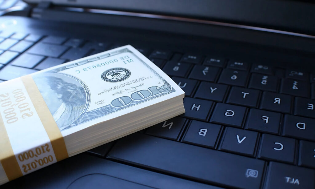 Como Ganhar Renda em Dólar e Proteger Seu Dinheiro da Alta da Moeda Imagem que ilustra a estratégia de ganhar renda em dólar e proteger seu dinheiro da alta da moeda, com um maço de notas de dólar sobre um teclado. 1. Pilha de dinheiro sobre um teclado de laptop, simbolizando estratégias para ganhar renda em dólar e proteger investimentos. 2. Montante de dinheiro posicionado em um teclado de laptop, representando métodos de proteção financeira em tempos de alta da moeda. 3. Dinheiro empilhado sobre um teclado de laptop, ilustrando a busca por renda em dólar e a segurança financeira. 4. Uma pilha de notas sobre um teclado de laptop, refletindo a importância de proteger o capital em meio à valorização da moeda. 5. Dinheiro acumulado em um teclado de laptop, destacando a relevância de estratégias para renda em dólar e segurança financeira. Como Ganhar Renda em Dólar e Proteger Seu Dinheiro da Alta da Moeda