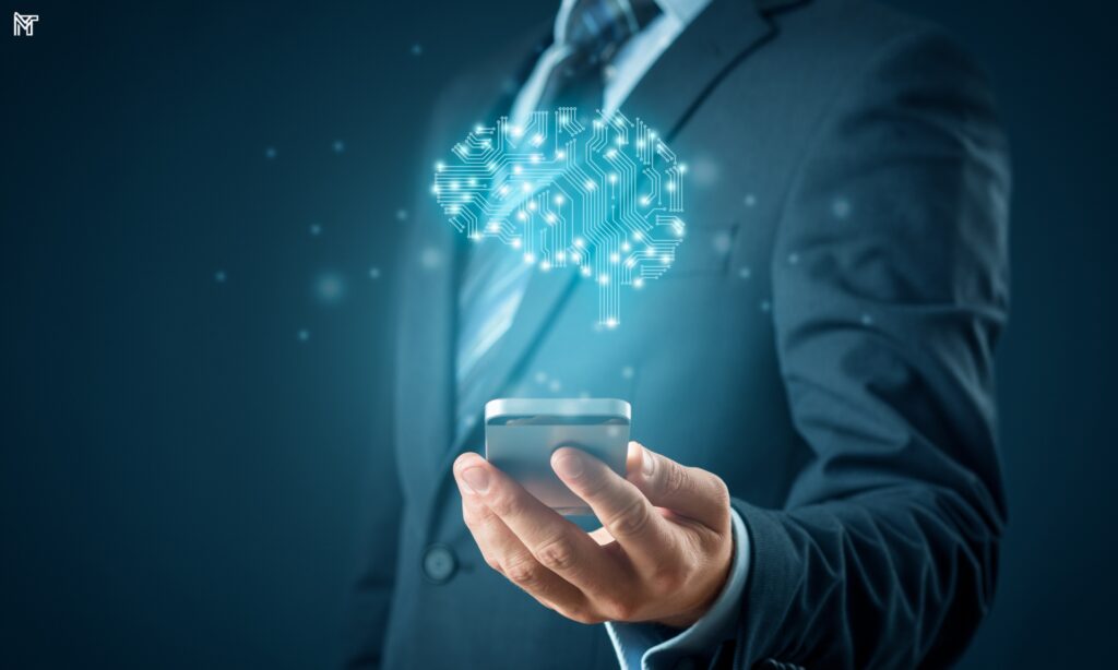 Como a IA Pode Beneficiar Investidores Individuais Imagem de um homem de negócios segurando um smartphone, com uma representação digital do cérebro humano ao fundo, simbolizando como a IA pode beneficiar investidores individuais. Inteligência Artificial e Investimentos: Como a Tecnologia Está Moldando o Mercado Financeiro